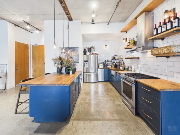 a large kitchen with stainless steel appliances granite countertop a lot of counter space and wooden floor
