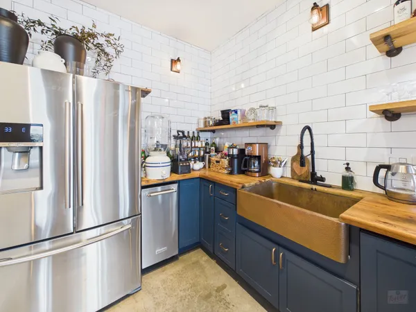 a kitchen with stainless steel appliances granite countertop a refrigerator and a sink