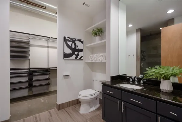 a bathroom with a granite countertop sink a toilet and a mirror