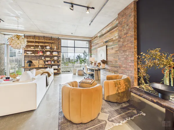 a living room with furniture a chandelier and a floor to ceiling window
