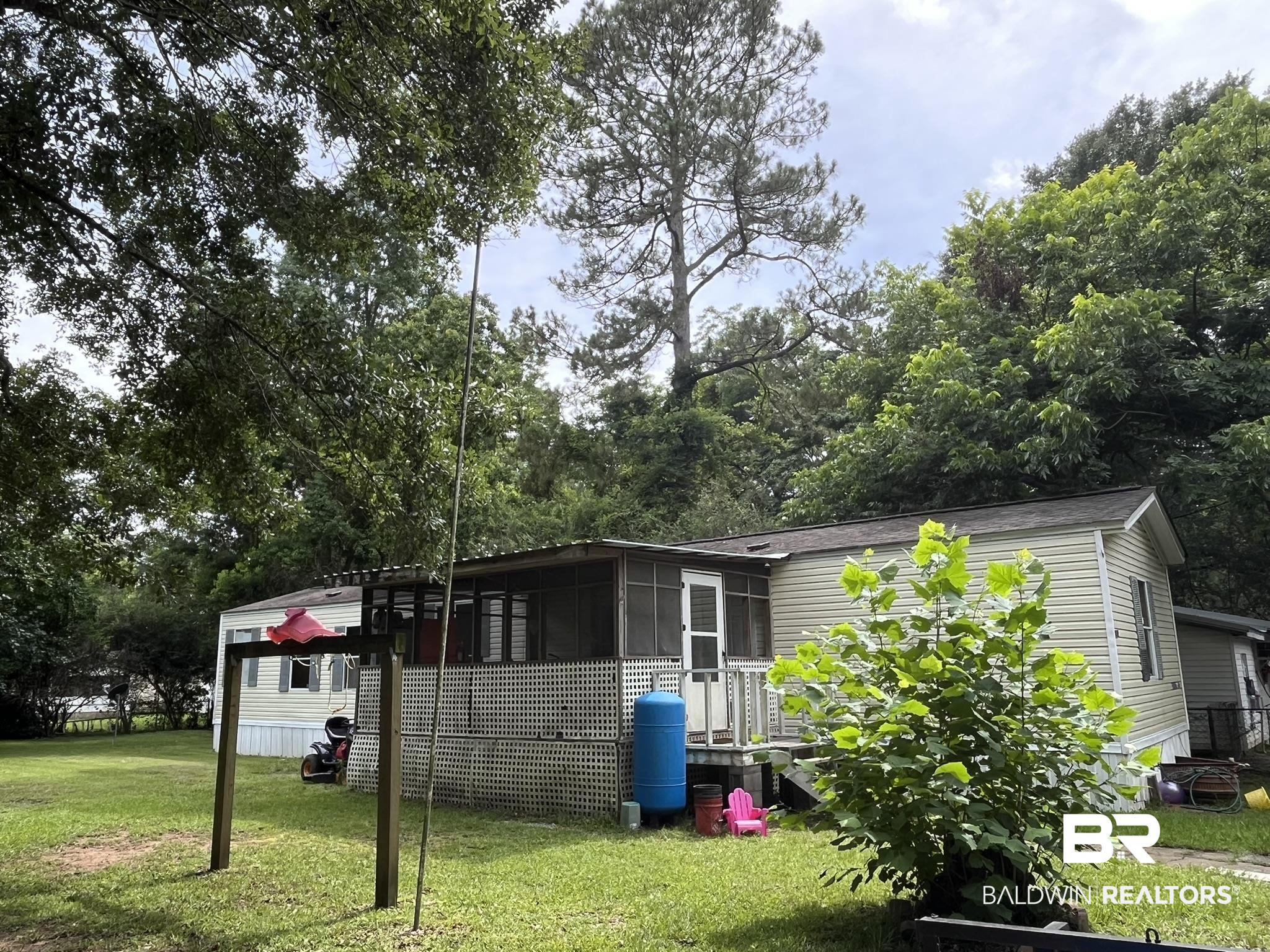 7719 Bermuda Drive Semmes, AL 36575 - Photo 1 of 10 View of property exterior with a sunroom and a yard