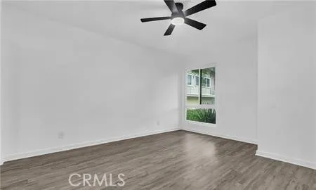 a view of a big room with wooden floor and windows