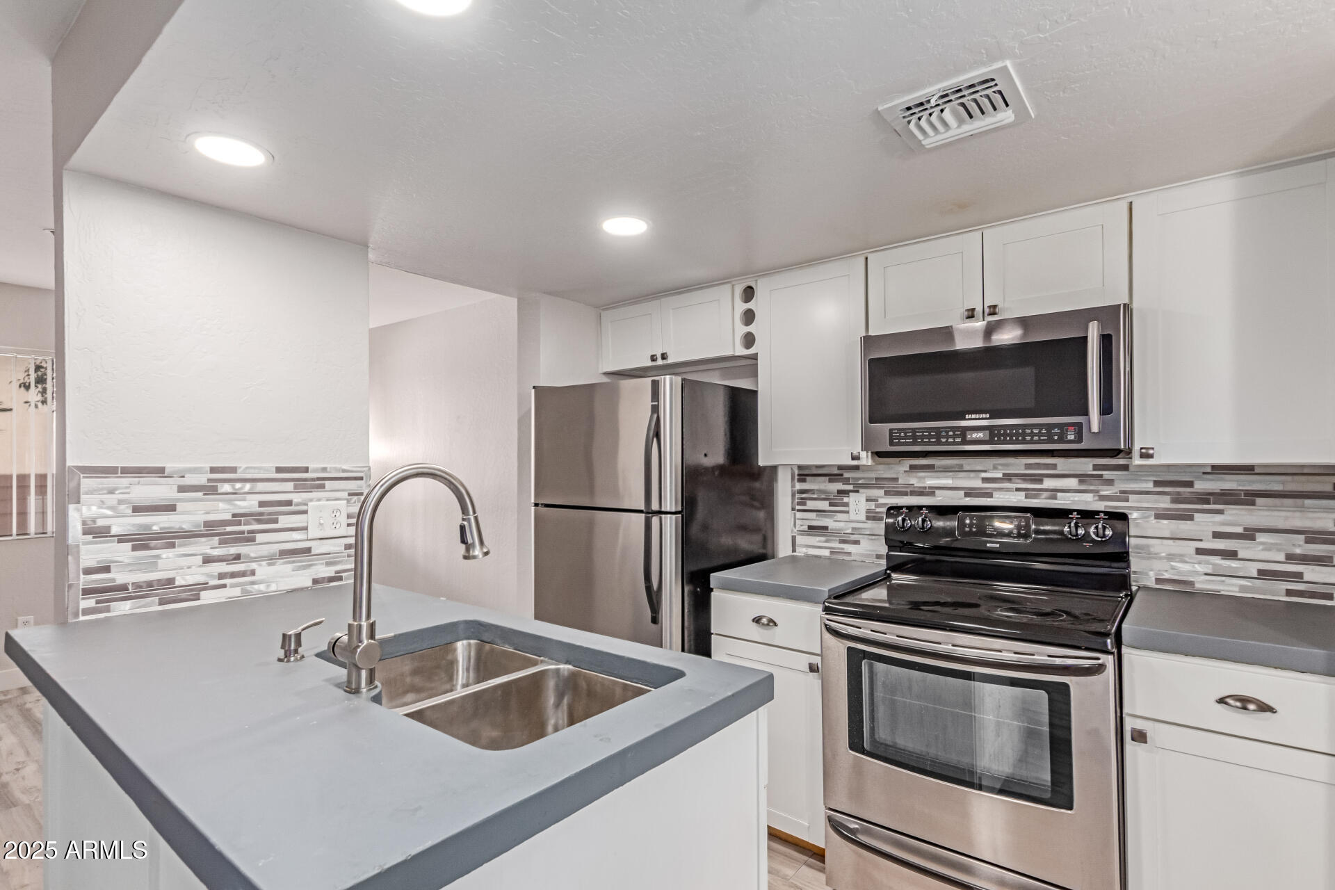 a kitchen with kitchen island a refrigerator stove and microwave