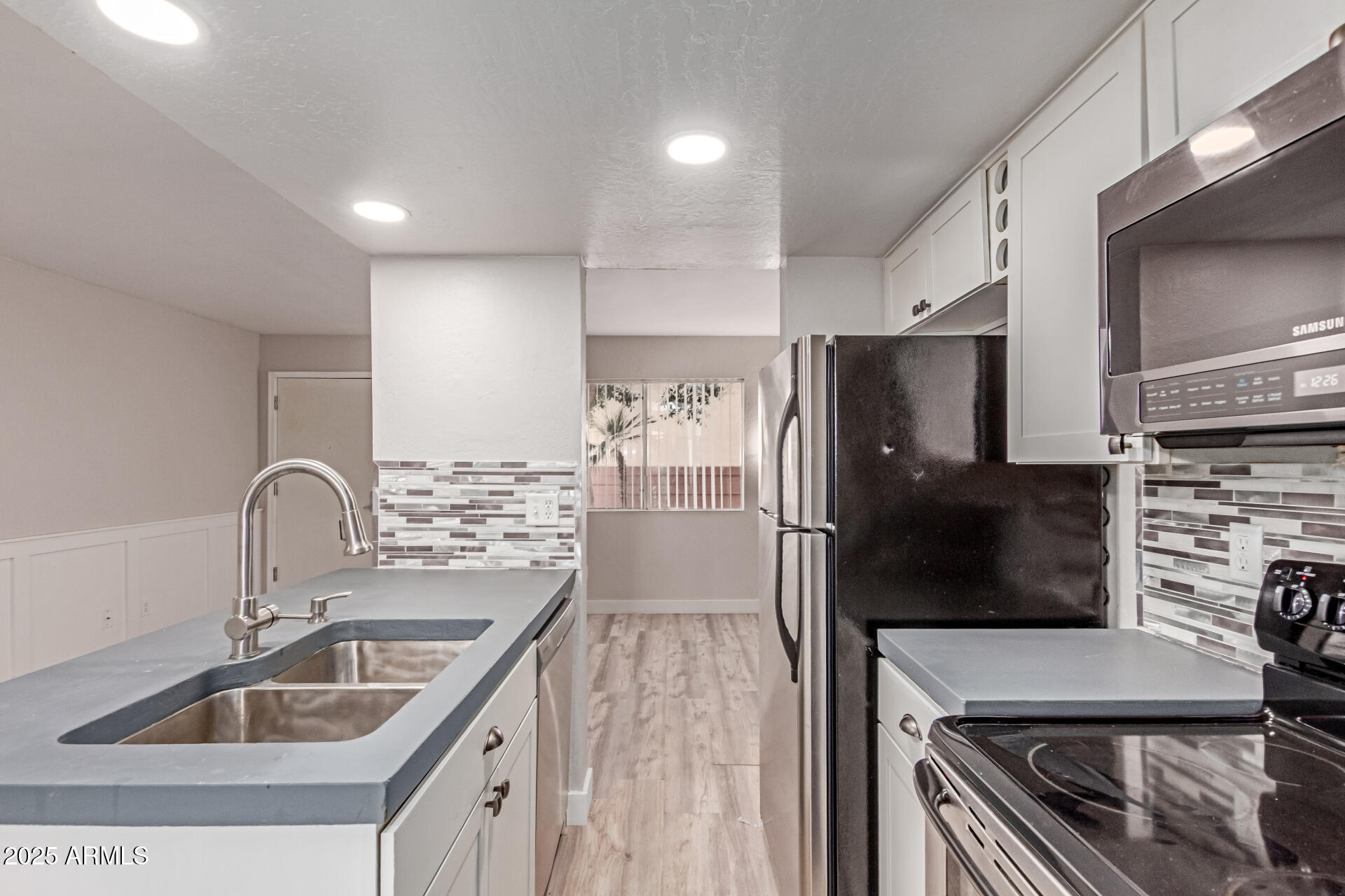 12123 West Bell Road, Unit 138 Surprise, AZ 85378 - Photo 17 of 28 a kitchen with kitchen island a sink stove and refrigerator