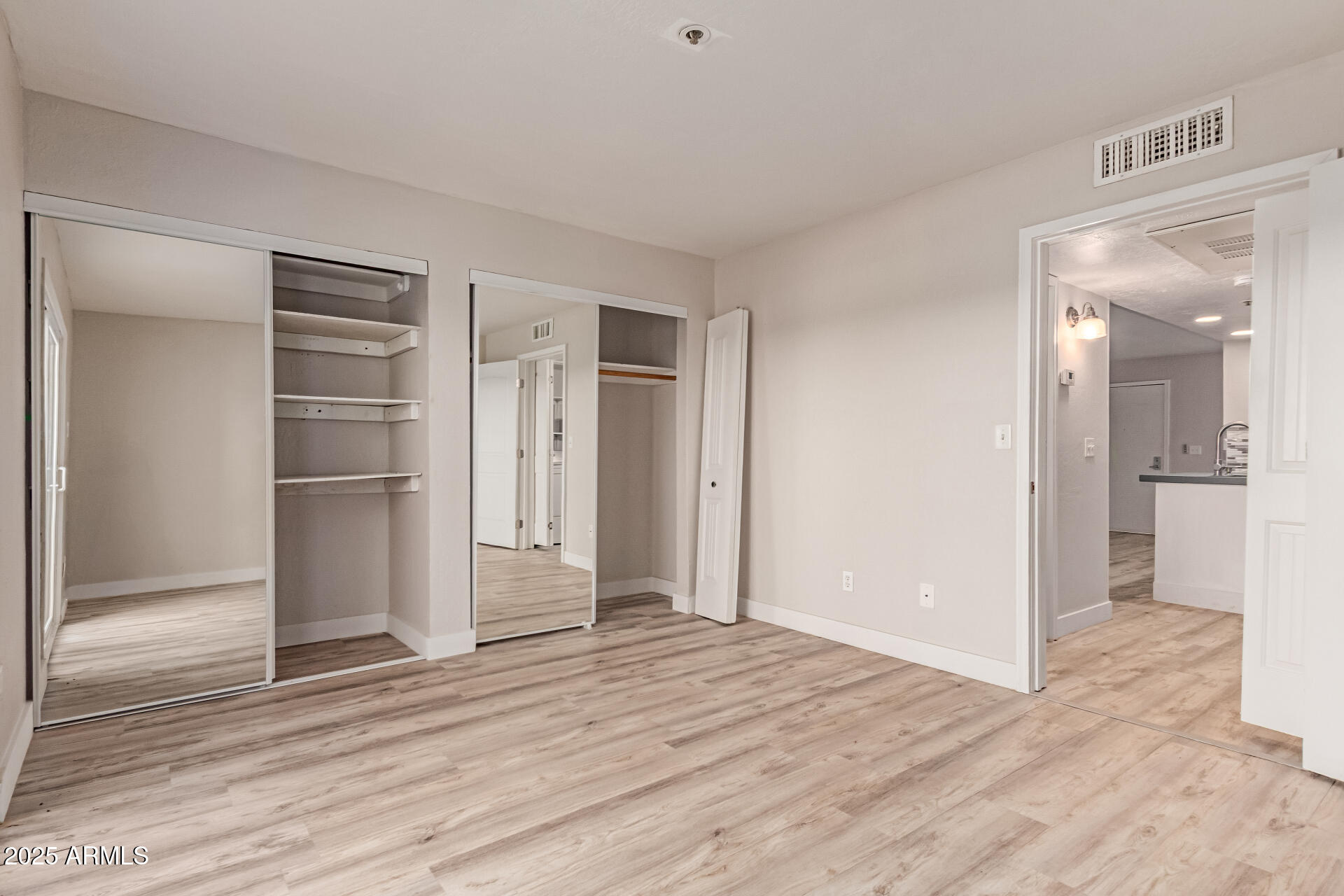 12123 West Bell Road, Unit 138 Surprise, AZ 85378 - Photo 18 of 28 a view of an empty room with wooden floor & kitchen space