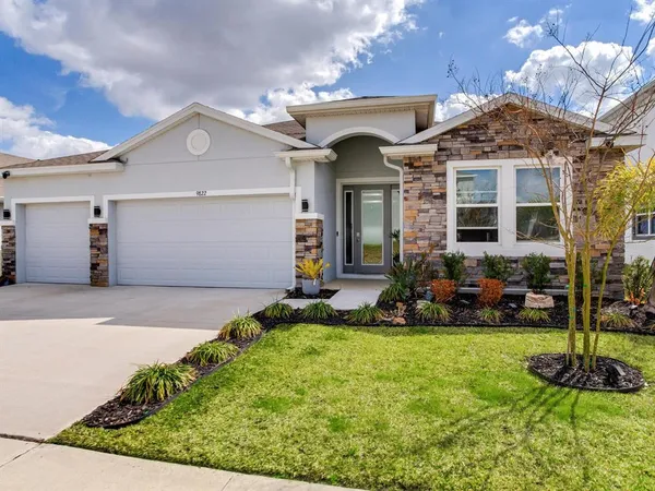 a front view of a house with a yard and garage