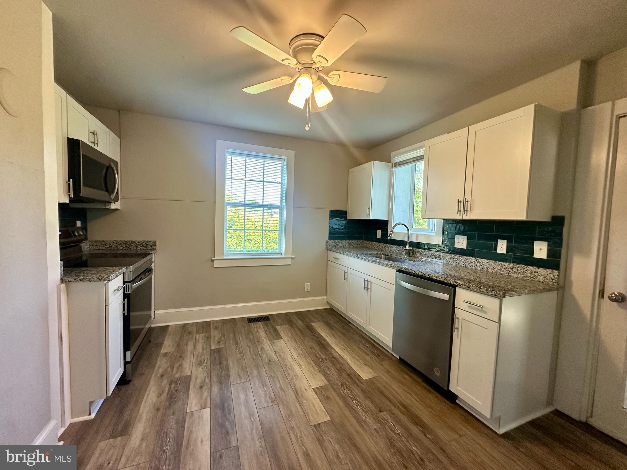 16142 Brandy Road Culpeper, VA 22701 - Photo 5 of 21 a kitchen with granite countertop a stove a sink a refrigerator and cabinets