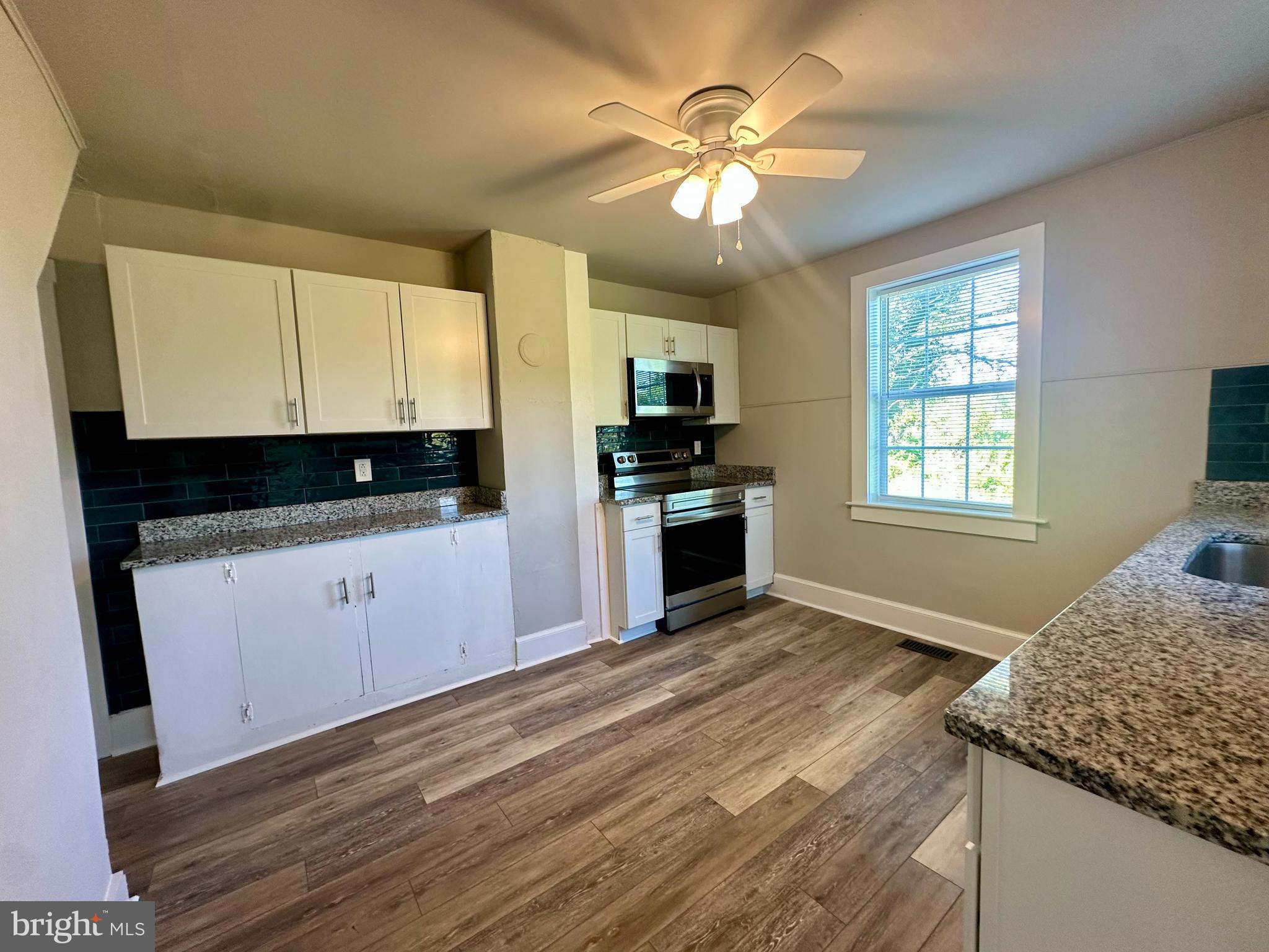 16142 Brandy Road Culpeper, VA 22701 - Photo 6 of 21 a kitchen with granite countertop a stove a sink and a microwave