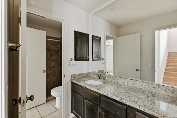 a bathroom with a granite countertop sink and a mirror