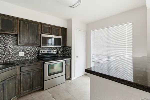 a kitchen with granite countertop cabinets stainless steel appliances and a counter space
