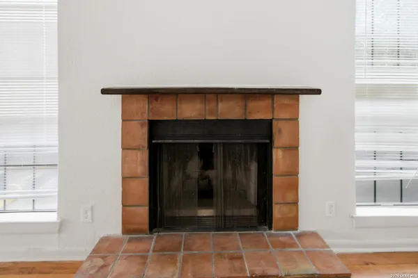 a view of a livingroom with wooden floor and a fireplace