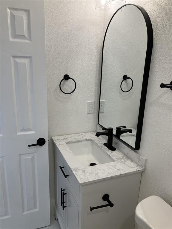 11630 79th Avenue Seminole, FL 33772 - Photo 14 of 14 a bathroom with a granite countertop sink and a mirror