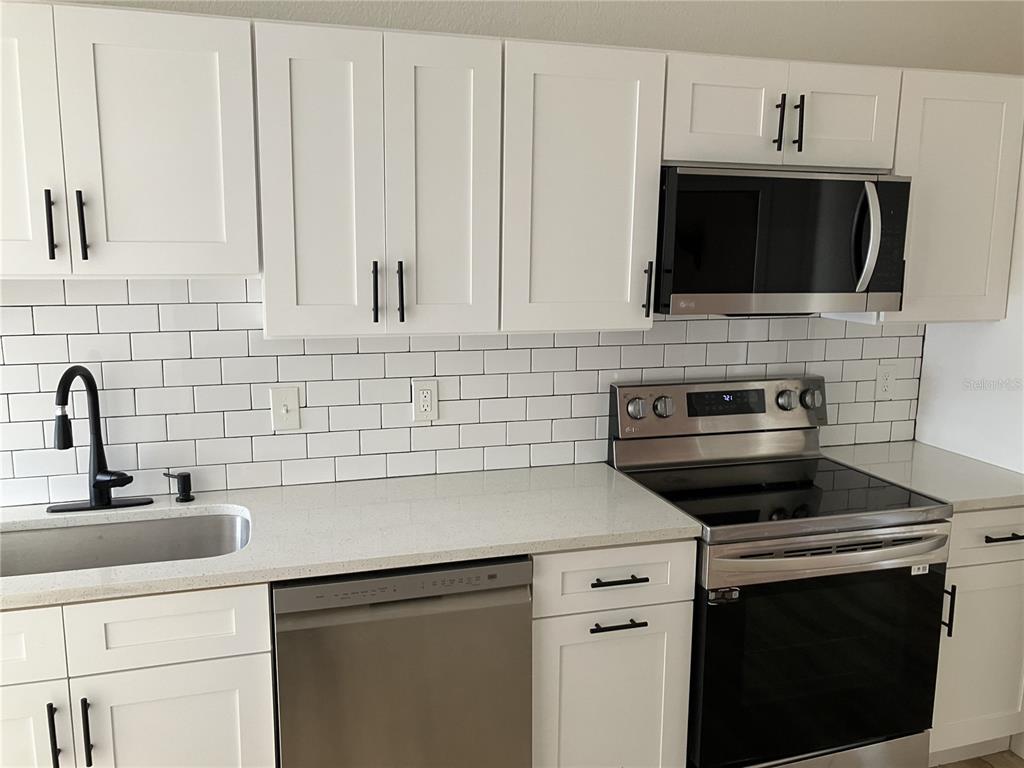 11630 79th Avenue Seminole, FL 33772 - Photo 10 of 14 a kitchen with a sink stove and microwave