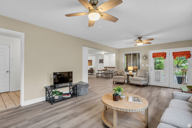 1539 East 450 South Springville, UT 84663 - Photo 15 of 49 Spacious living area featuring light wood-finish flooring, neutral wall tones, and two ceiling fans with integrated lighting