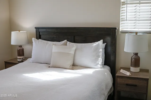 a large bed sitting in a bedroom next to a lamp