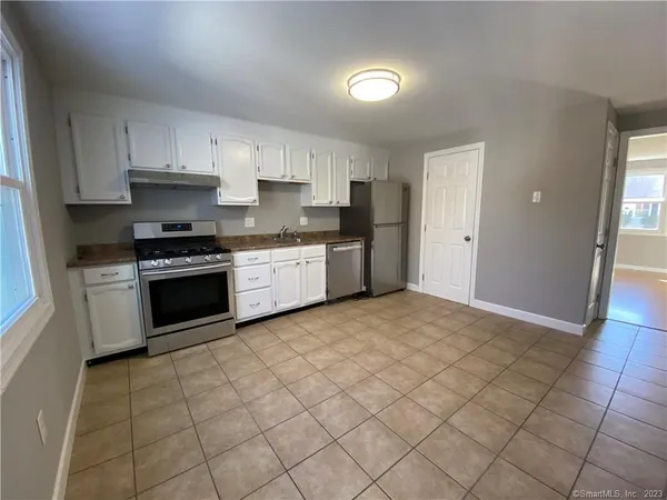 a kitchen with stainless steel appliances granite countertop a stove a sink and a refrigerator