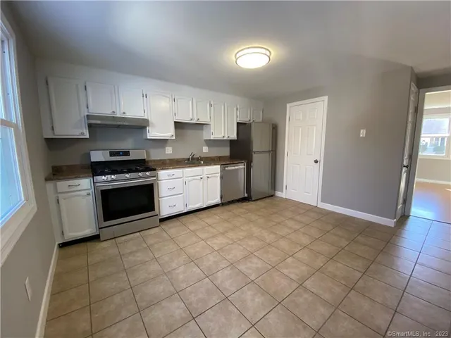 a kitchen with stainless steel appliances granite countertop a stove a sink and a refrigerator