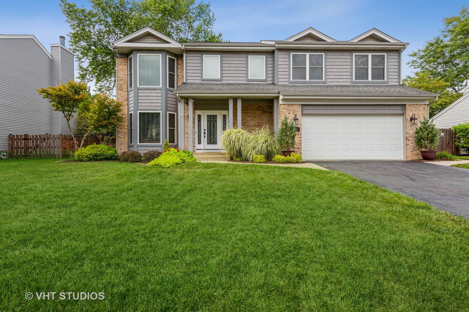 a front view of a house with a garden and yard
