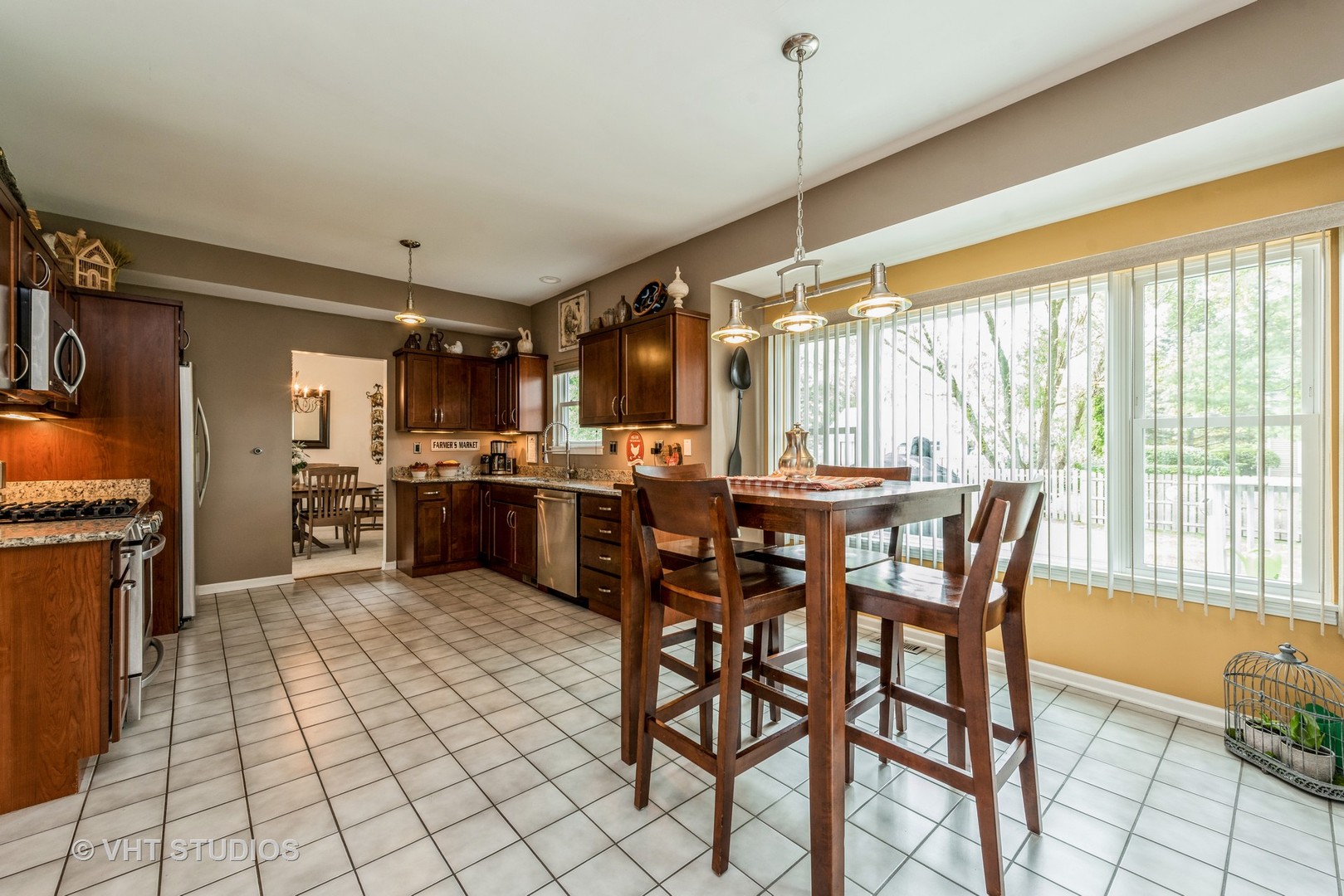 Undisclosed Address Algonquin, IL 60102 - Photo 10 of 40 a open kitchen with stainless steel appliances granite countertop a stove top oven a sink a dining table and chairs with wooden floor