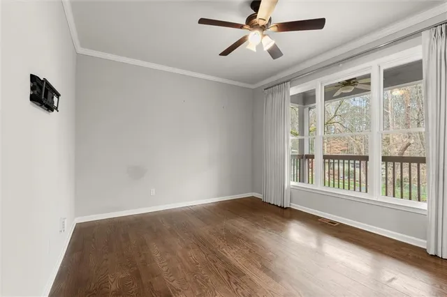 a view of an empty room with a window and a ceiling fan