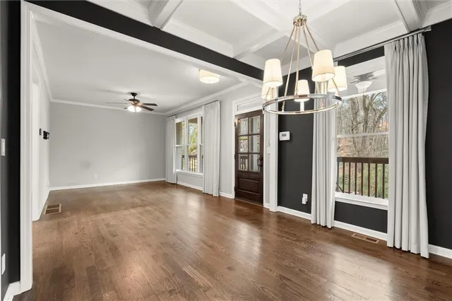 a view of a hallway with wooden floor and chandelier