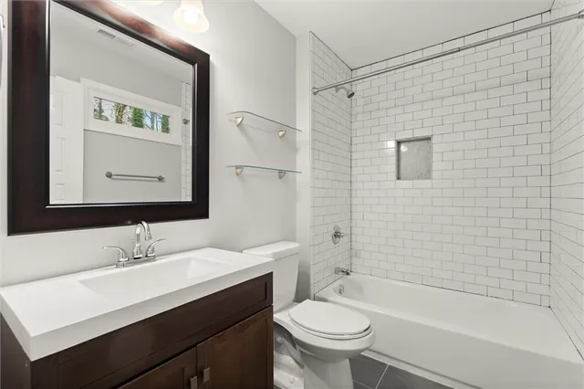a bathroom with a sink mirror toilet and bathtub
