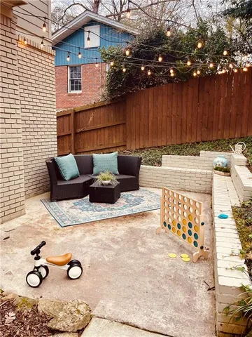 a view of backyard with seating space and wooden fence