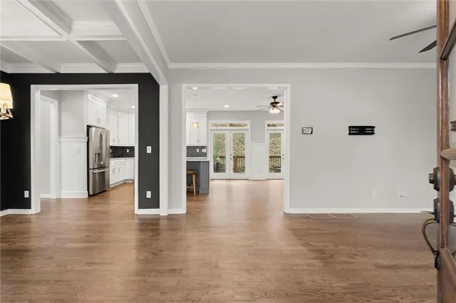 a view of a hallway with wooden floor and windows
