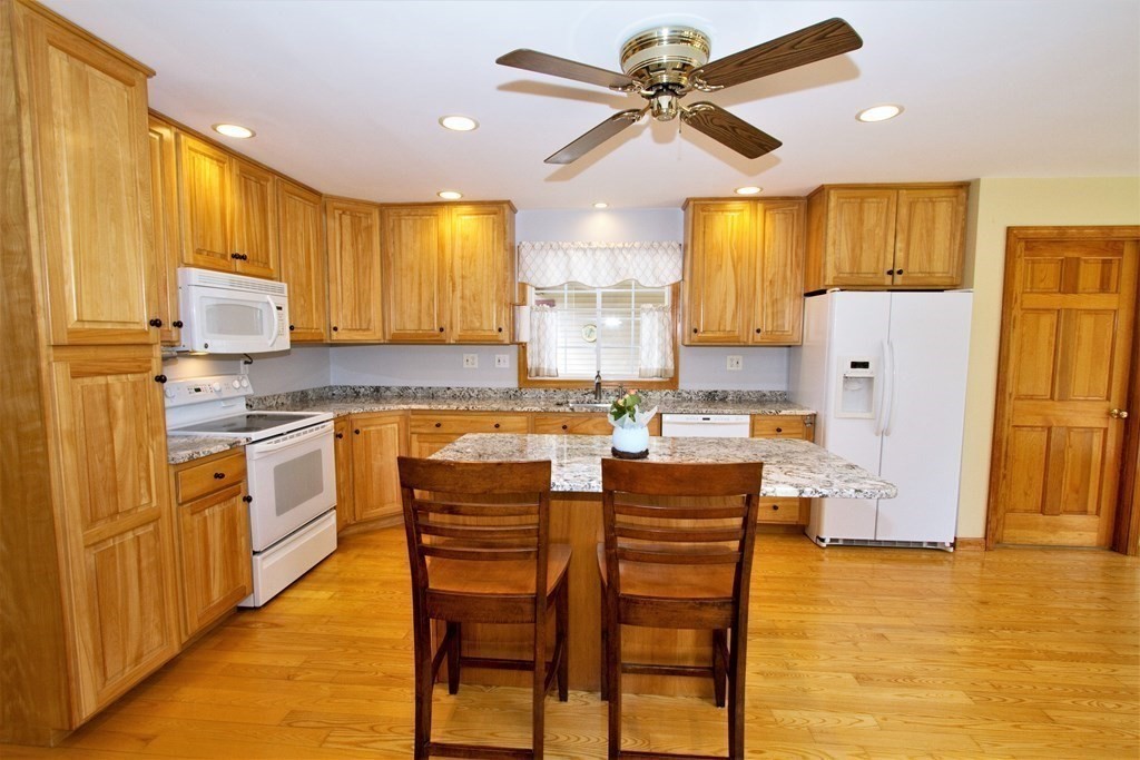22 Edgemere Road North Reading, MA 01864 - Photo 4 of 42 a kitchen with a refrigerator a center island a stove cabinets dining table and chairs