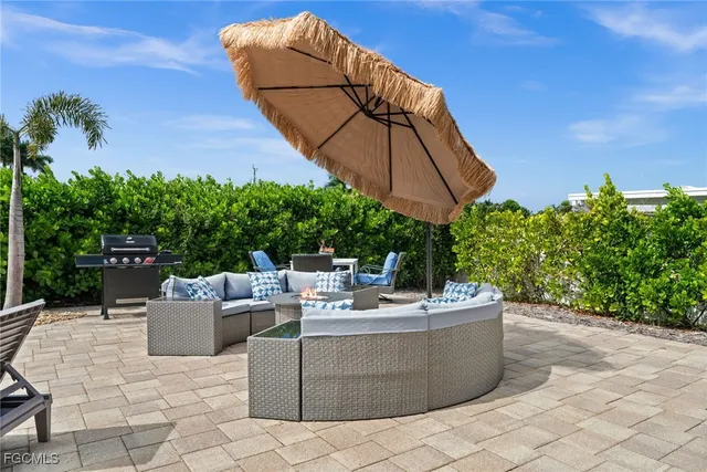 a view of a patio with a table and chairs under an umbrella