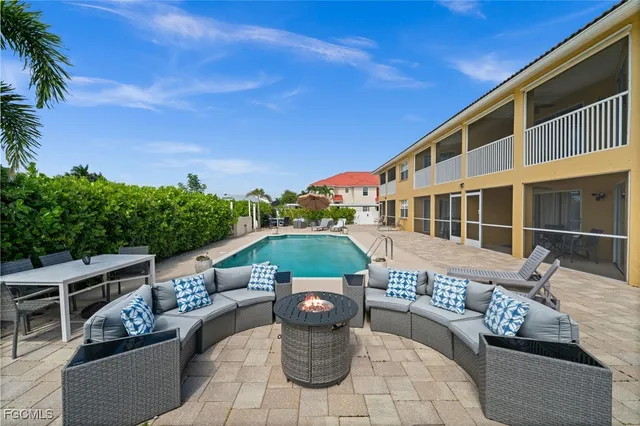 a view of a patio with couches table and chairs and potted plants