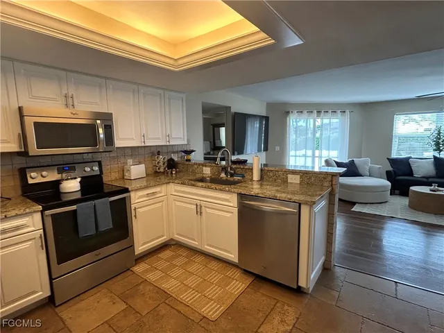 a kitchen with stainless steel appliances a stove a sink and a microwave