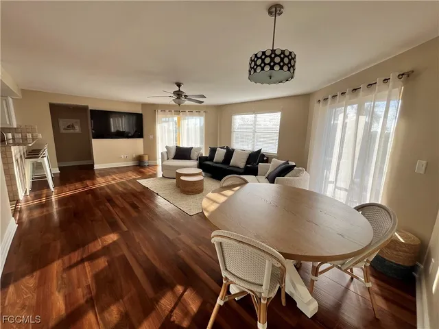 a living room with furniture a flat screen tv and a large window