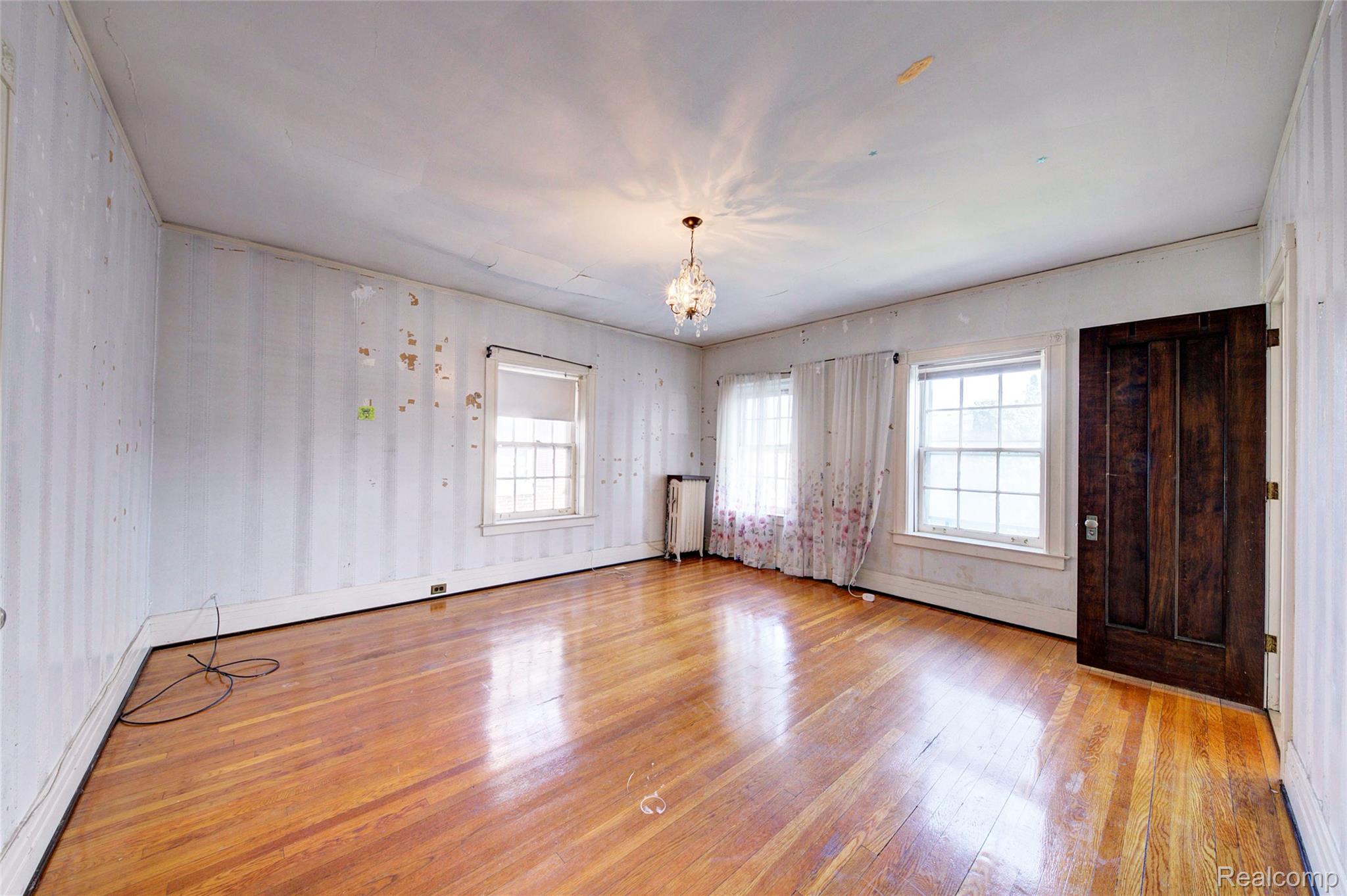 121 Longfellow Street Detroit, MI 48202 - Photo 46 of 87 Unfurnished room featuring suspended lighting, light wood-type flooring, plenty of natural light, and radiator