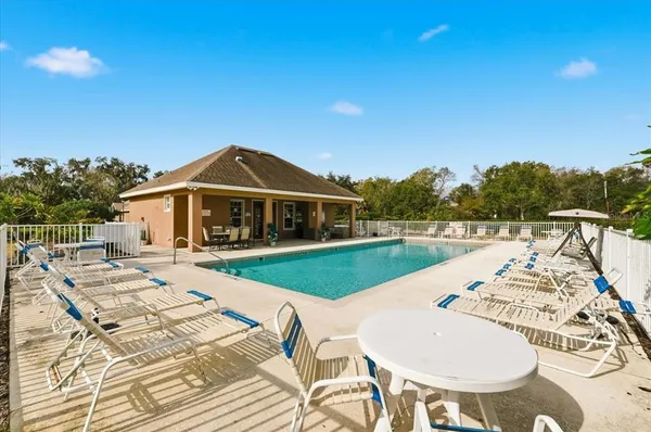 a view of a house with swimming pool and sitting area