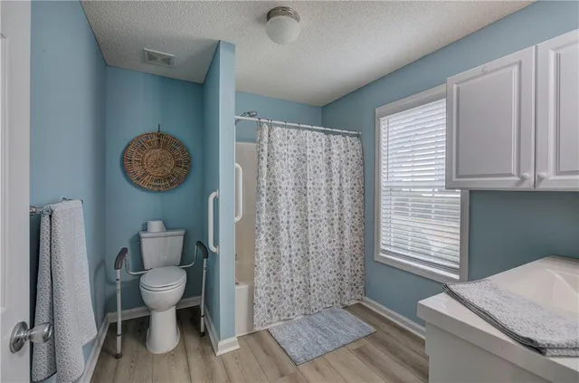 a bathroom with a toilet a sink and a window