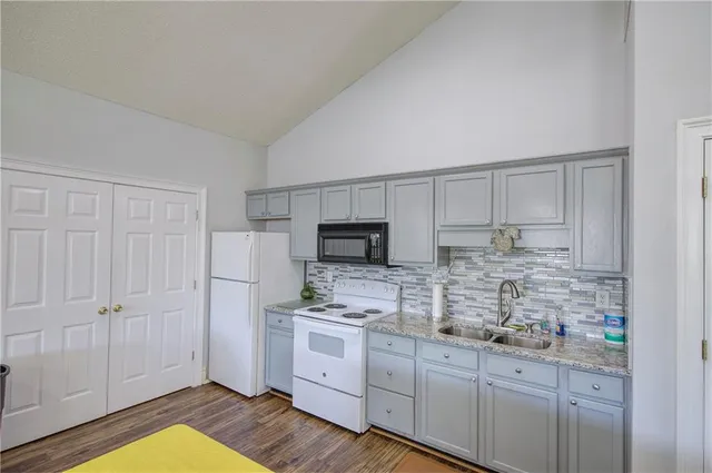 a kitchen with granite countertop white cabinets and stainless steel appliances
