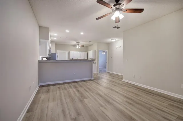 wooden floor in an empty room with a kitchen