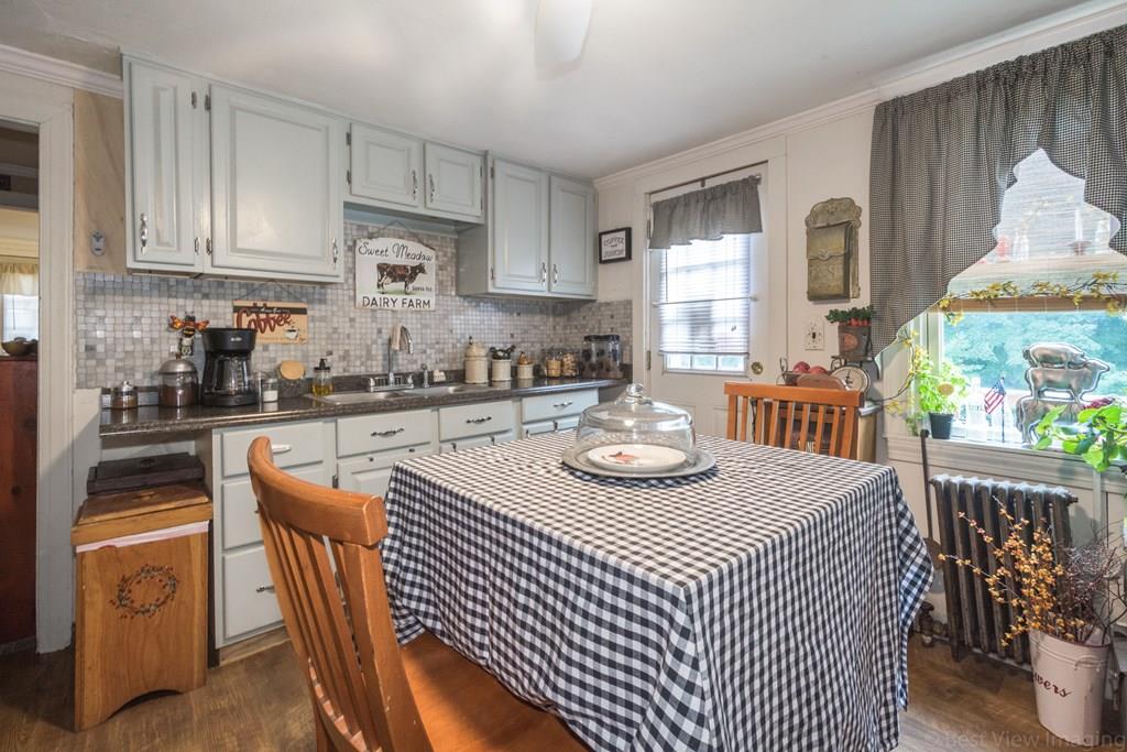 148 Sterling Road Lancaster, MA 01523 - Photo 29 of 39 a kitchen with stainless steel appliances granite countertop a sink a stove a dining table and chairs with wooden floor