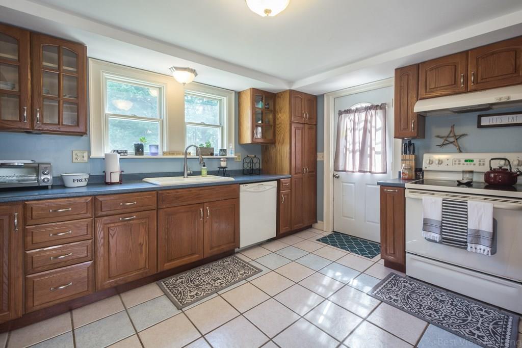 148 Sterling Road Lancaster, MA 01523 - Photo 10 of 39 a kitchen with stainless steel appliances granite countertop a stove a sink and a refrigerator