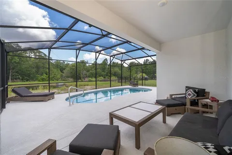 a view of a swimming pool with a couches and table