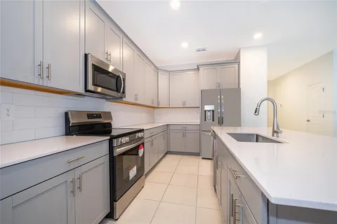 a kitchen with granite countertop white cabinets and stainless steel appliances