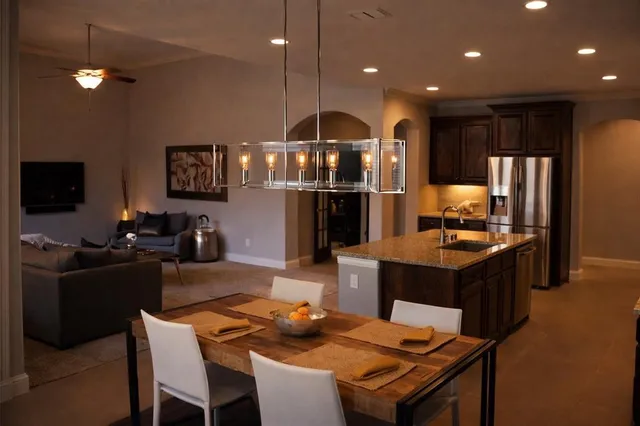 a kitchen with a dining table chairs and refrigerator