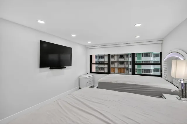 a large bedroom with a bed and a flat screen tv