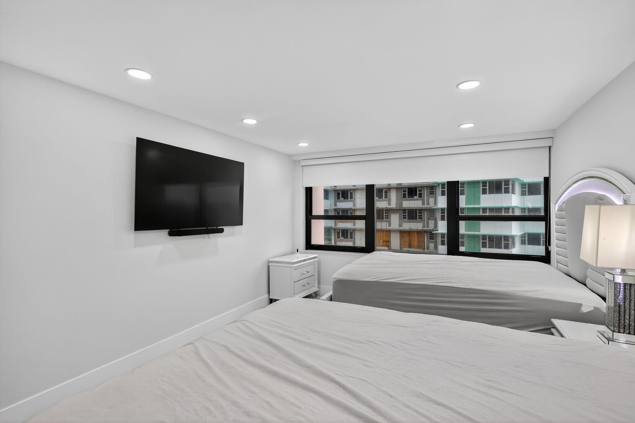 5225 Collins Avenue, Unit 1408 Miami Beach, FL 33140 - Photo 12 of 37 a large bedroom with a bed and a flat screen tv