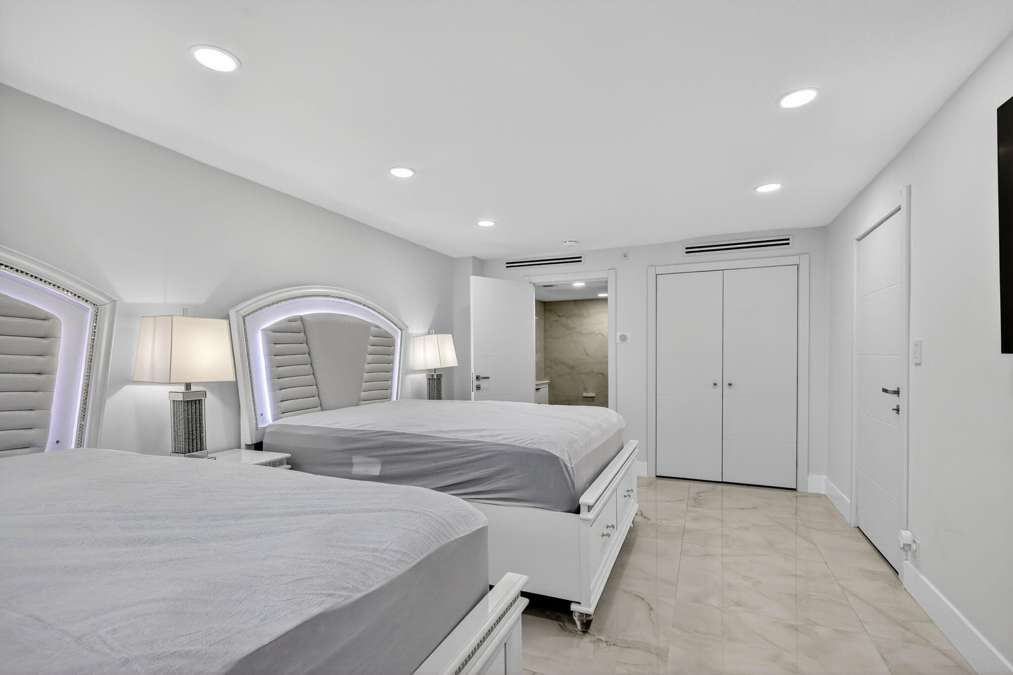 5225 Collins Avenue, Unit 1408 Miami Beach, FL 33140 - Photo 13 of 37 a bedroom with a large bed and a chandelier