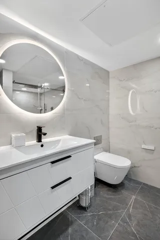 a bathroom with a sink a toilet and a mirror