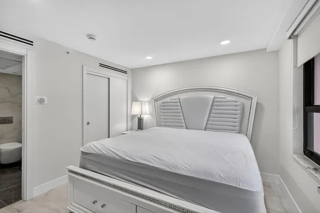 a bedroom with a bed and a refrigerator