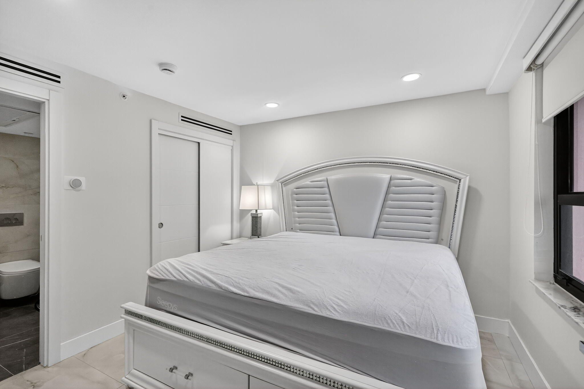 5225 Collins Avenue, Unit 1408 Miami Beach, FL 33140 - Photo 16 of 37 a bedroom with a bed and a refrigerator