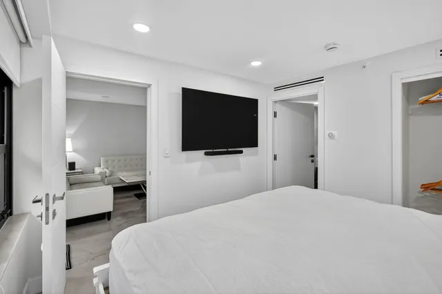 a bedroom with a bed and a flat screen tv